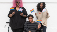 Three women holding pride flags.